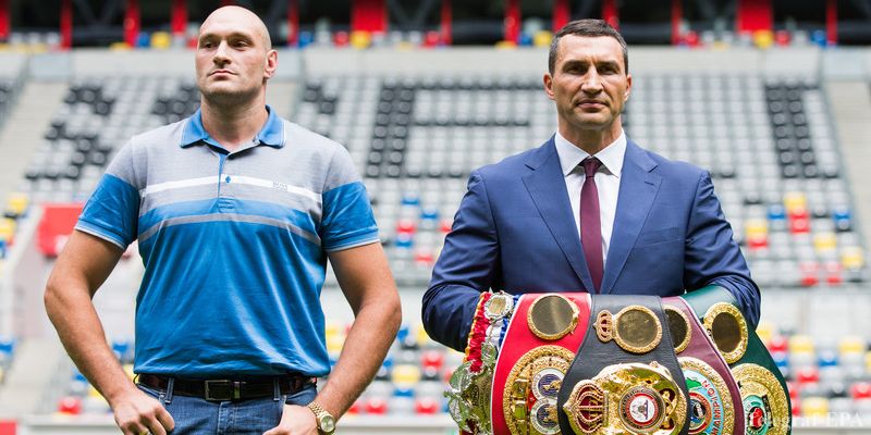 epa04855472 Ukranian WBA, WBO, IBO and IBF heavyweight world champion boxer Wladimir Klitschko (R), holds up his belts as he poses next to his British contender Tyson Fury at the Esprit Arena in Duesseldorf, Germany, 21 July 2015. Klitschko faces Tyson Fury in a title bout on 24 October 2015 in Duesseldorf.  EPA/ROLF VENNENBERND