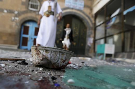 People walk past a headgear lying on the ground at the al-Balili mosque after two bombings at the mosque in Yemen's capital Sanaa, September 24, 2015. REUTERS/Khaled Abdullah