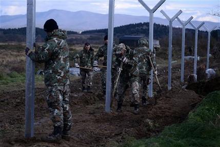 Macedonian army build a border fence to prevent illegal crossings by migrants, in the Greek-Macedonian border near the Greek village of Idomeni on Saturday, Nov. 28, 2015. Macedonia toughened rules for crossings earlier this month, in the wake of the deadly Paris attacks, restricting access to citizens from countries typically granted asylum in Europe, including Syria and Afghanistan. (AP Photo/Giannis Papanikos)