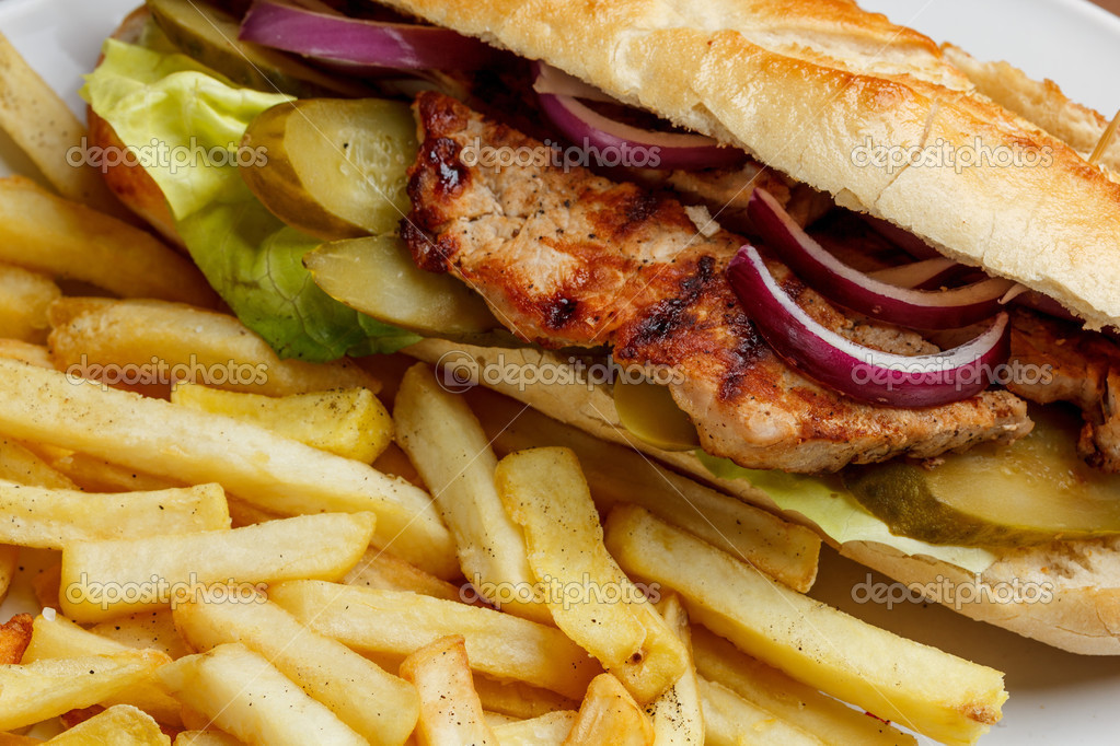 Close up of grilled pork sandwich with french fries